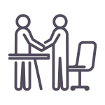 Line icon of two people standing at a desk shaking hands.