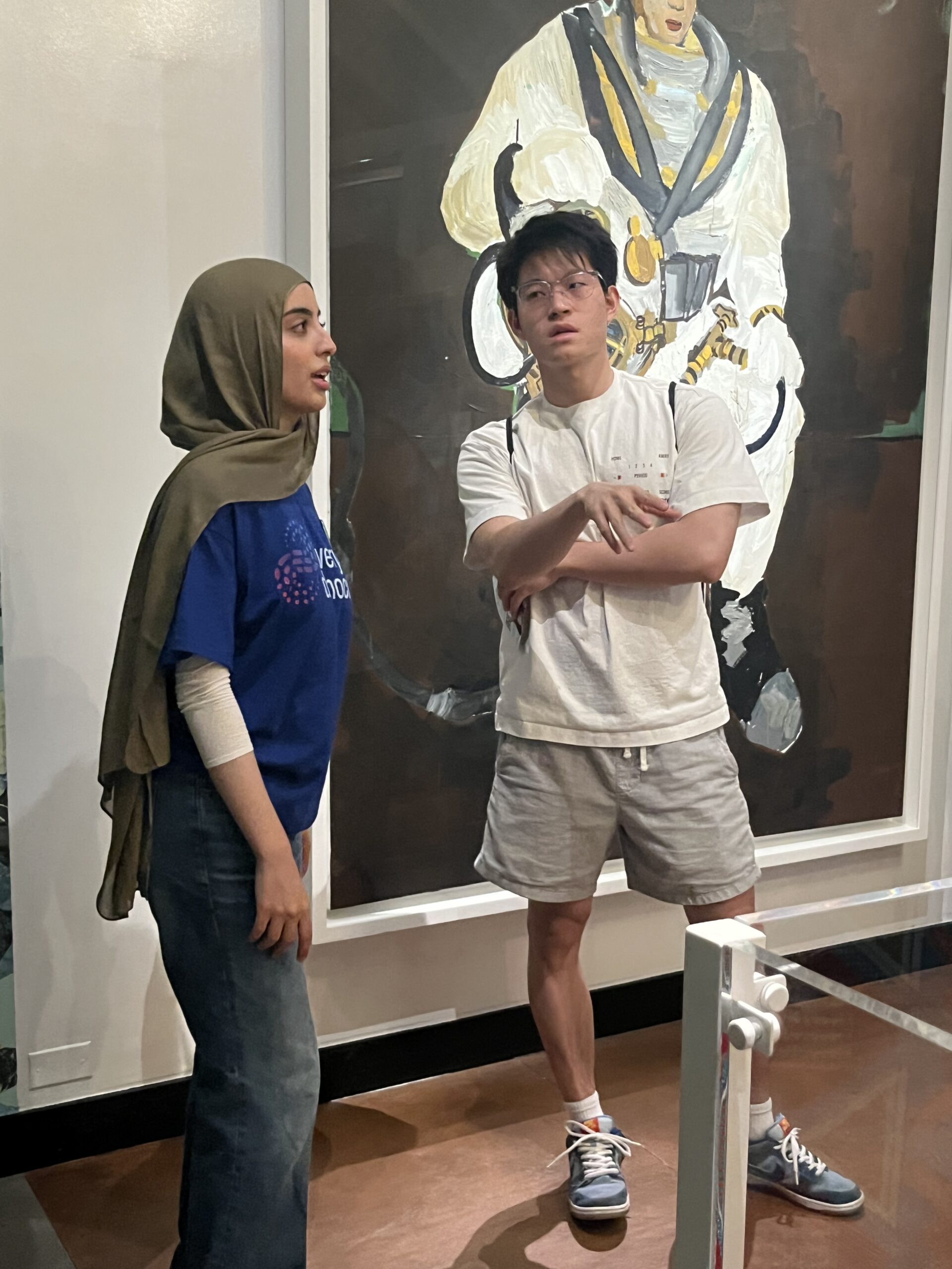 IMG_4265 A young woman speaking with a young man in an art gallery.
